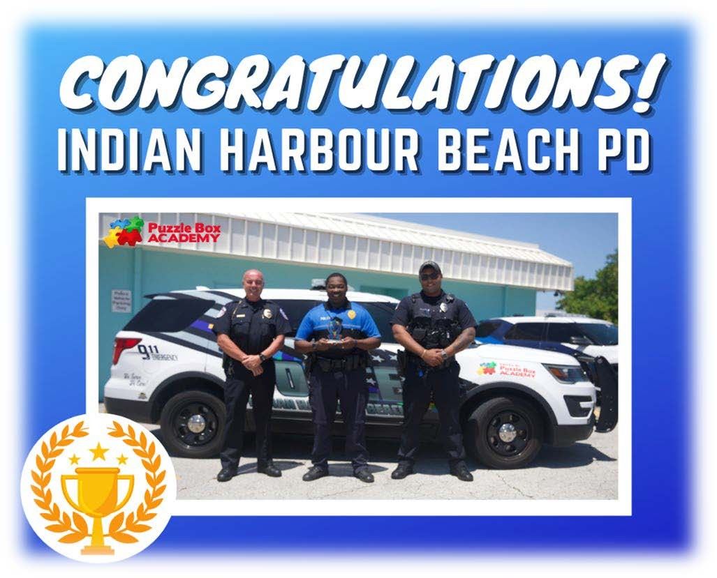 Puzzle Box Academy presented the Police with a trophy for winning the police vehicle wrap contest